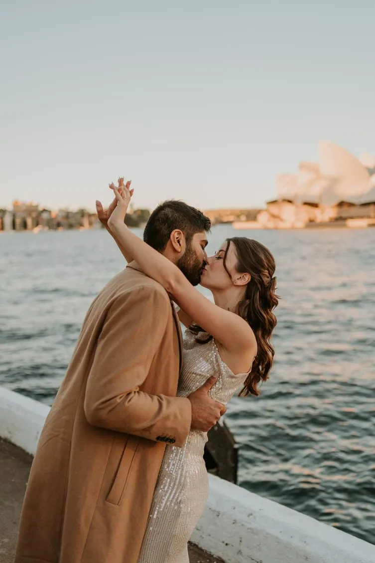 A couple kissing beside Sydney Harbour