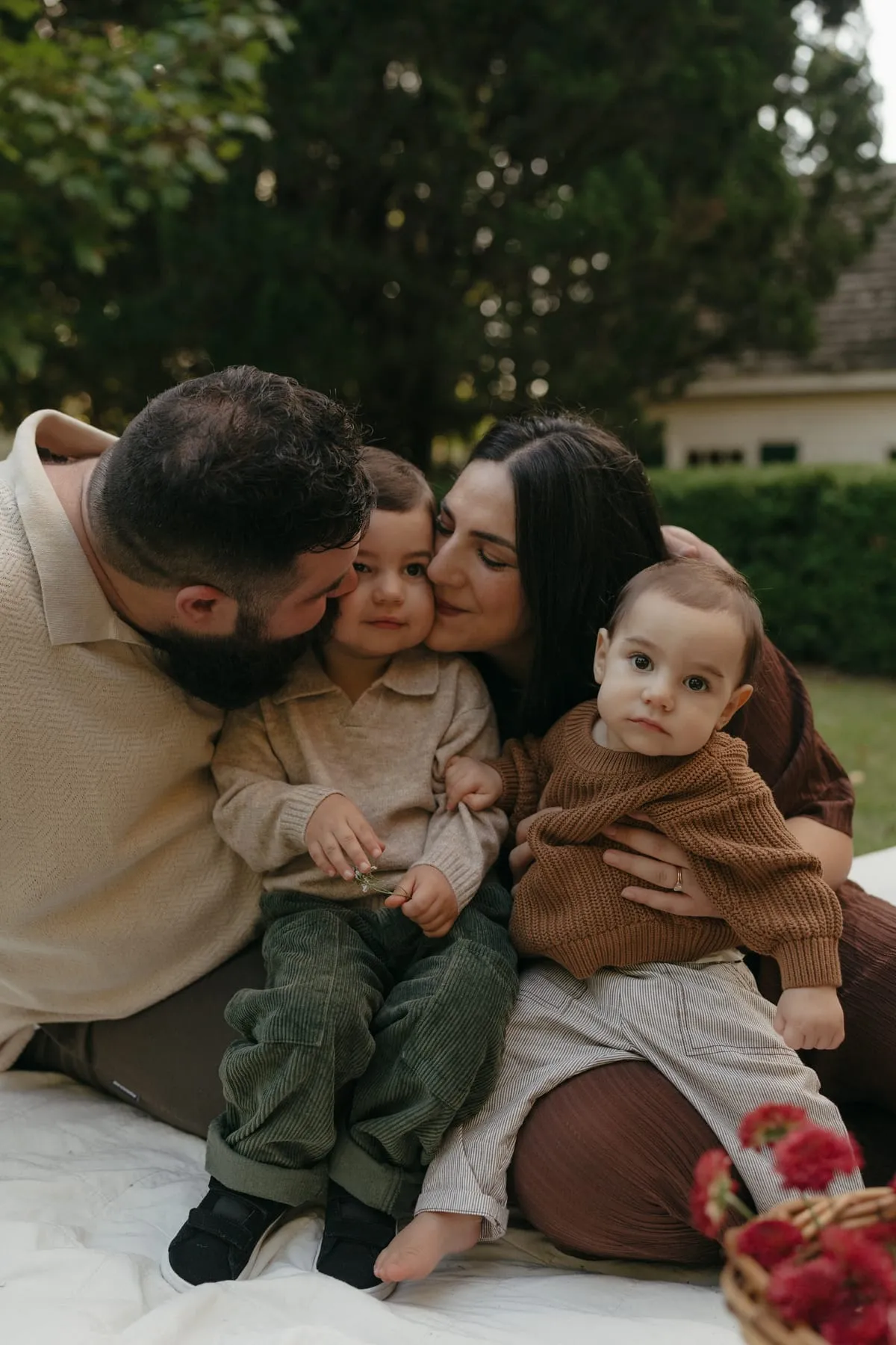 A dad kissing his two kids at a picnic