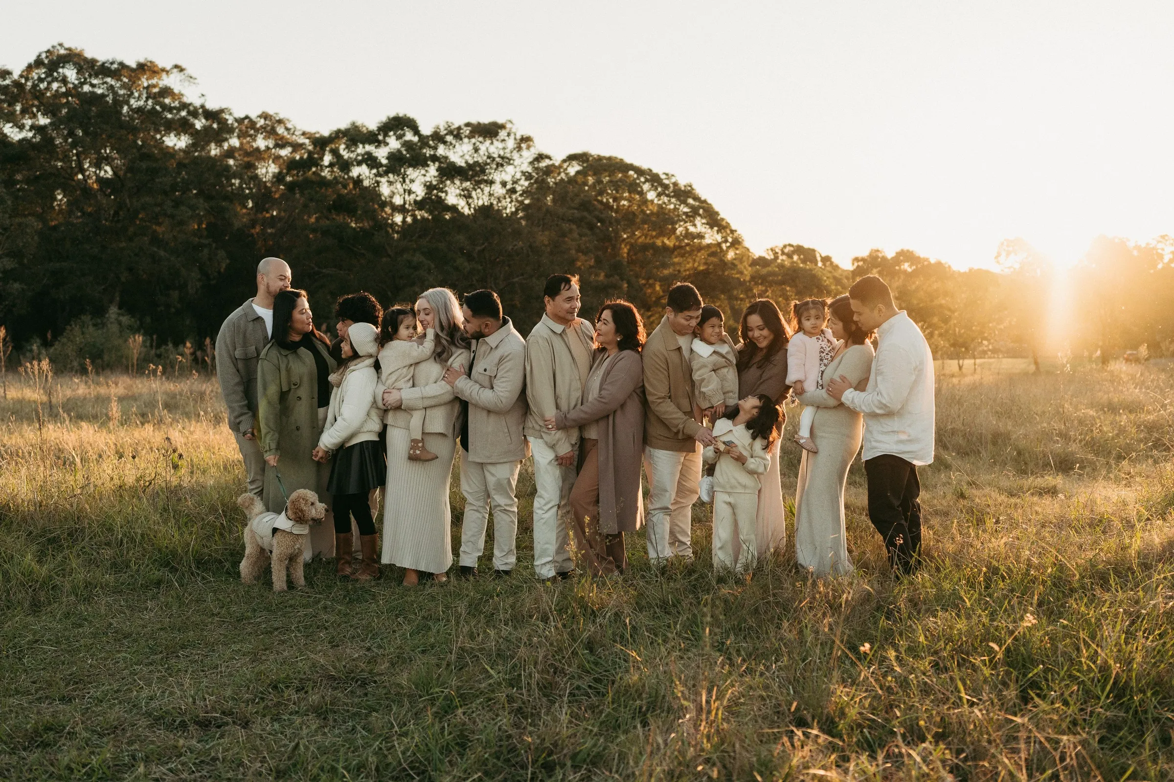 An extended family gathered in long grass in the evening sun